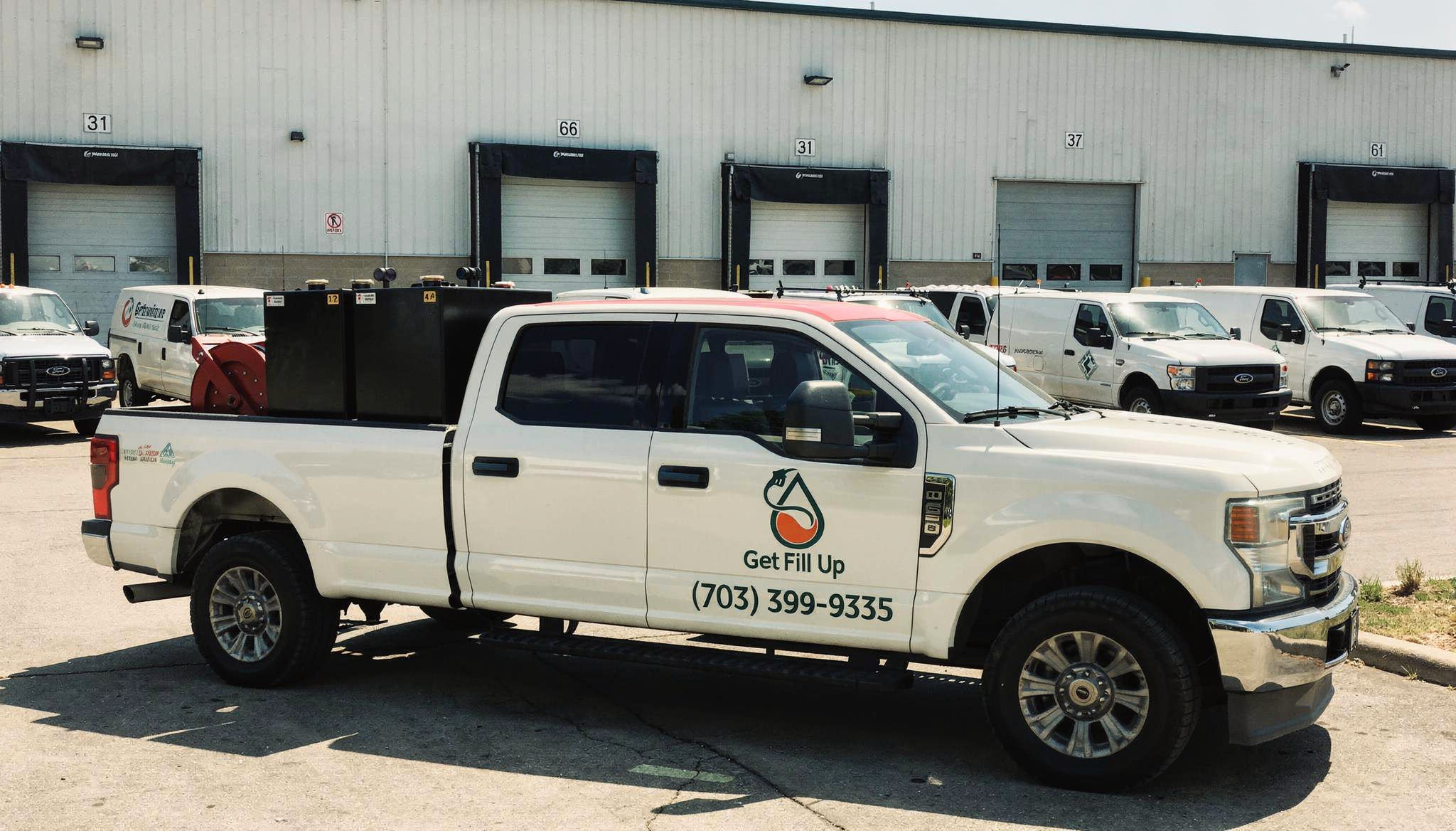 Get Fill Up truck beside commercial delivery vans at a fleet depot